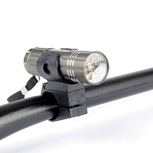 Zdjęcie przedstawia uniwersalną lampę przednią do roweru z uchwytem montażowym. Widoczna jest kompaktowa obudowa oraz element mocujący umożliwiający dopasowanie do różnych modeli rowerów.